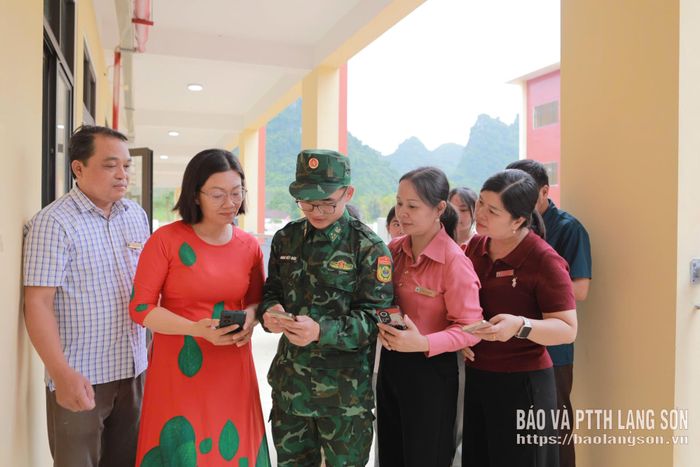 Cán bộ Đồn Biên phòng Pò Mã hướng dẫn cán bộ, giáo viên Trường Phổ thông Nội trú Tiểu học và THCS Quốc Khánh sử dụng mô hình "Tủ sách pháp luật số"