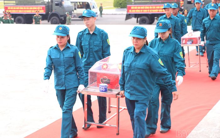Lực lượng dân quân tham gia đưa linh cữu hài cốt liệt sĩ về đến Đài tưởng niệm các Anh hùng liệt sĩ, phường Cam Đường.