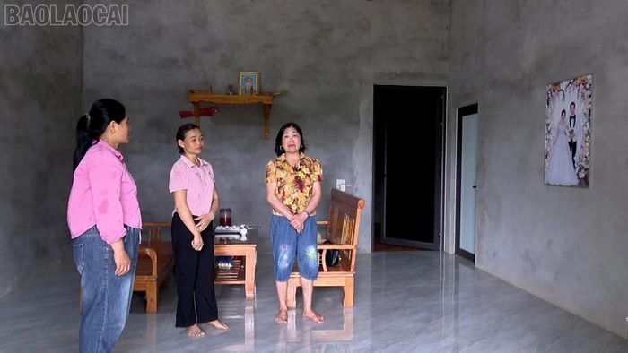 Chị Vũ Thị Loan (đứng giữa) trong căn nhà kiên cố được hỗ trợ xây dựng.