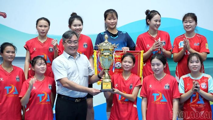 Ông Nông Việt Yên - Giám đốc Sở Văn hóa, Thể thao và Du lịch tỉnh trao Cup vô địch cho các cầu thủ CLB Thiên An xã Lục Yên.