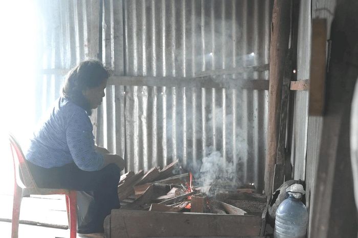 Bà K'Thị Hên nhóm bếp củi, chuẩn bị nấu bữa trưa. Ảnh: Ngọc Hiển