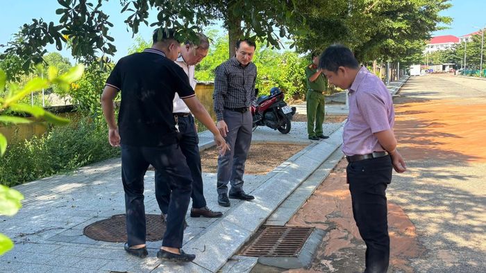 Chủ tịch UBND phường Phú Thủy Nguyễn Văn Nghị (thứ ba từ trái qua) kiểm tra hiện trường vụ lũ cát gây sạt cục bộ đường 1/5