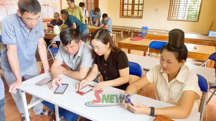 Cán bộ Đảng ủy xã Chiềng Khoong hướng dẫn đảng viên cài đặt, sử dụng Sổ tay Đảng viên điện tử.