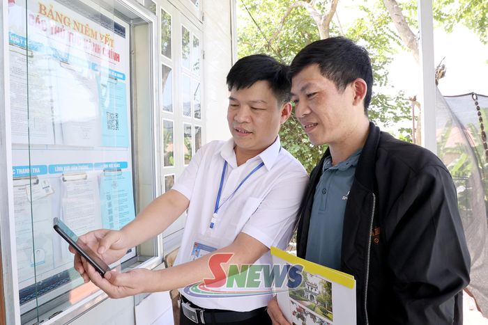 Cán bộ Trung tâm Phục vụ hành chính công xã Song Khủa hướng dẫn người dân đánh giá chỉ số hài lòng trong giải quyết thủ tục hành chính.