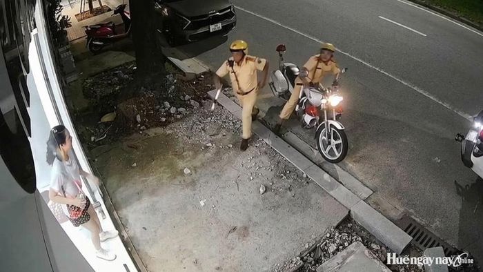 Hai cán bộ CSGT tiếp cận, hỗ trợ đưa người bệnh đi cấp cứu. (Hình ảnh trích xuất từ camera nhà dân).