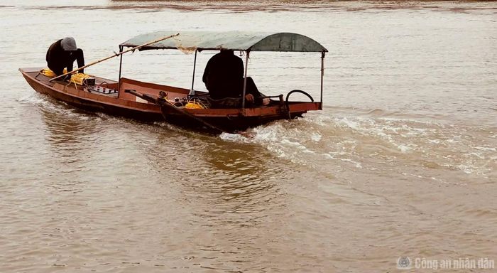 Hai người đàn ông trên chiếc thuyền có trang bị bộ kích điện công suất lớn bắt đầu cho một hành trình đánh bắt cá trên sông Hồng.