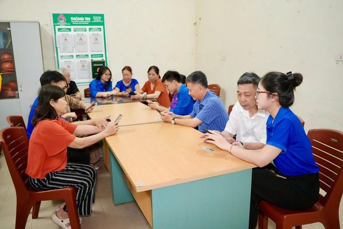 Đoàn viên thanh niên hỗ trợ người dân tiếp cận các tiện ích số tại nhà sinh hoạt cộng đồng. Ảnh: H.Duy