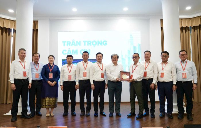 Đại diện lớp đào tạo, bồi dưỡng cán bộ của Thủ đô Viêng Chăn (Lào) tặng quà lưu niệm cho Phó Chủ tịch UBND thành phố Hà Nội Trương Việt Dũng. Ảnh: Hồng Thái
