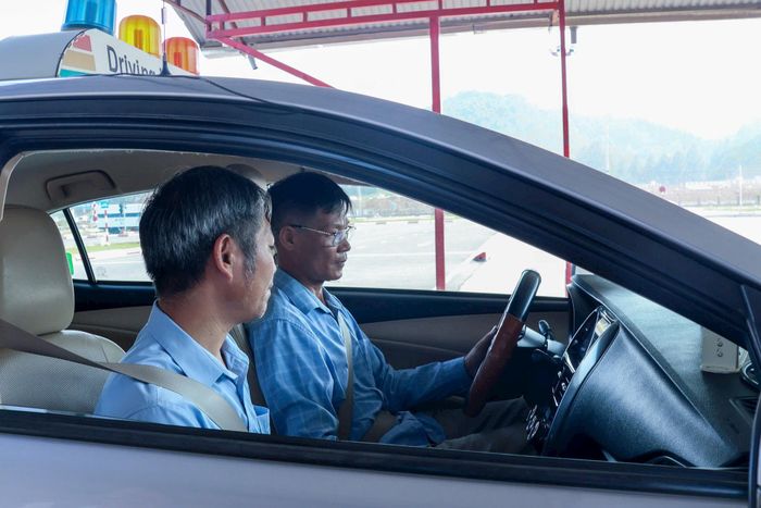 Giáo viên hướng dẫn học viên các thao tác trước khi khởi hành xe tập lái. Ảnh minh hoạ