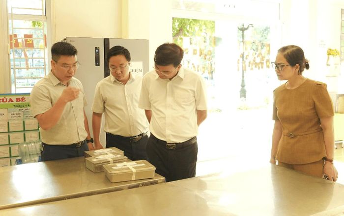 Kiểm tra việc lưu mẫu thức ăn sau chế biến tại Trường Mầm non Gia Lâm. Ảnh: M.H