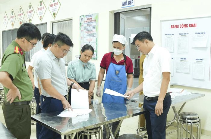 Đoàn kiểm tra sổ sách ghi chép việc nhập thực phẩm tại Trường Tiểu học Cổ Bi. Ảnh: M.H