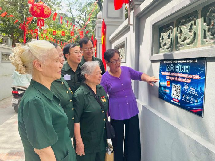 Phó Bí thư Chi bộ, Trưởng ban Công tác Mặt trận khu dân cư 22 Trương Thị Ngoãn giới thiệu về QR Hanoi. Ảnh: Bảo Lâm
