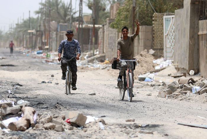 Người dân di chuyển trên một tuyến phố ở Fallujah, Iraq, ngày 27-9. Thành phố Fallujah từng là một trung tâm kháng chiến lớn chống lực lượng Mỹ. Ảnh: Reuters
