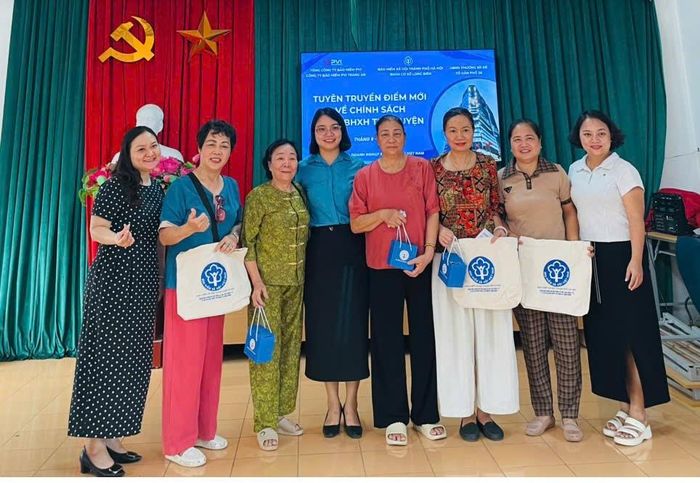 BHXH cơ sở Long Biên tặng quà tới người dân đăng ký tham gia chính sách ngay sau hội nghị tuyên truyền. Ảnh: PV