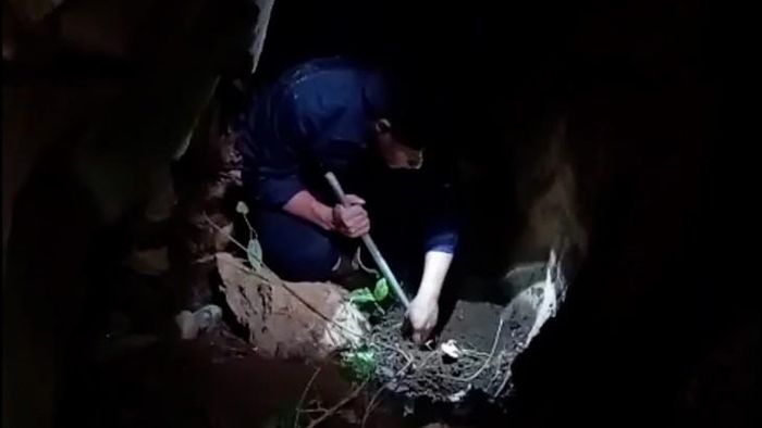 Hài cốt nằm trong hang đá nhỏ chật hẹp, việc quy tập gặp không ít khó khăn. Ảnh: Hoàng Cuối.