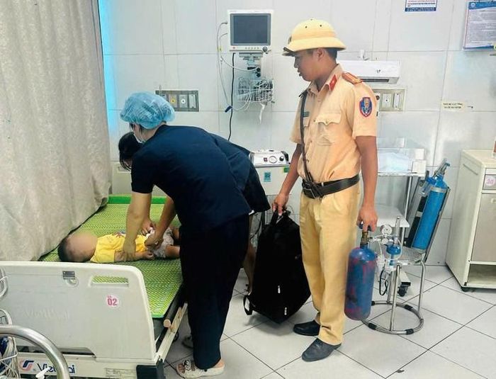 Tổ công tác CSGT nhanh chóng hỗ trợ đưa cháu bé bị co giật vào bệnh viện cấp cứu kịp thời. Ảnh: Cơ quan công an.