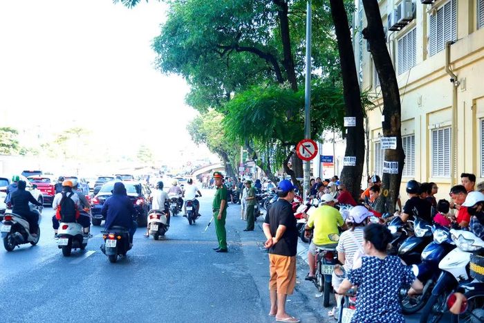 Xe máy của phụ huynh được xếp sát vỉa hè hoặc tập trung tại khu vực quy định, giữ lại phần lớn mặt đường cho dòng xe cộ lưu thông