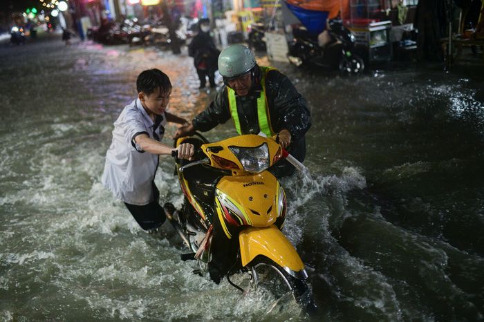  Lực lượng chức năng có mặt để hỗ trợ người dân qua đoạn ngập sâu. 