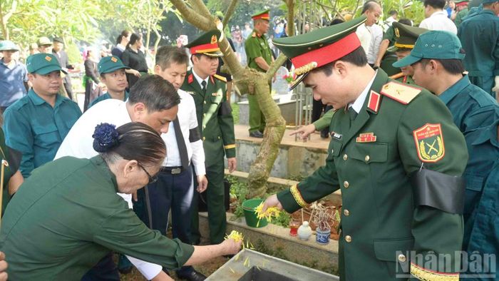 Các đại biểu cùng người dân an táng hài cốt các Anh hùng liệt sĩ. (Ảnh: CÔNG HẢI)