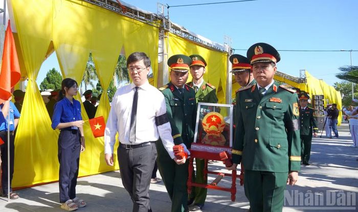 Các đại biểu tiễn đưa các liệt sĩ về nơi an nghỉ. (Ảnh: H.M)