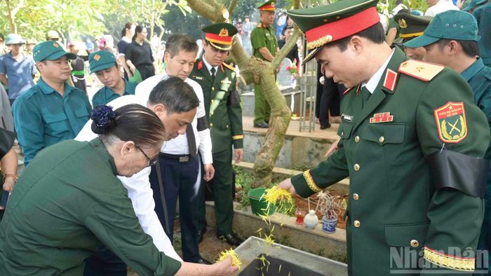 Các đại biểu cùng nhân dân an táng các Anh hùng liệt sĩ. (Ảnh: CÔNG HẢI)