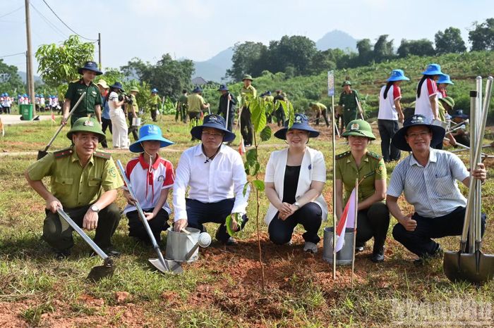 Các đại biểu chụp ảnh tại cây vừa trồng ngay sau buổi lễ.