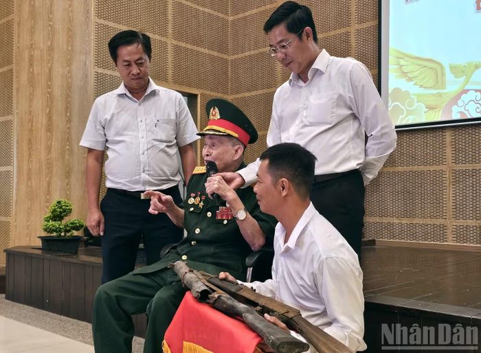 Anh hùng lực lượng vũ trang nhân dân Nguyễn Văn Tàu kể về những kỷ vật kháng chiến của mình. (Ảnh: LÊ ĐÌNH THÌN)