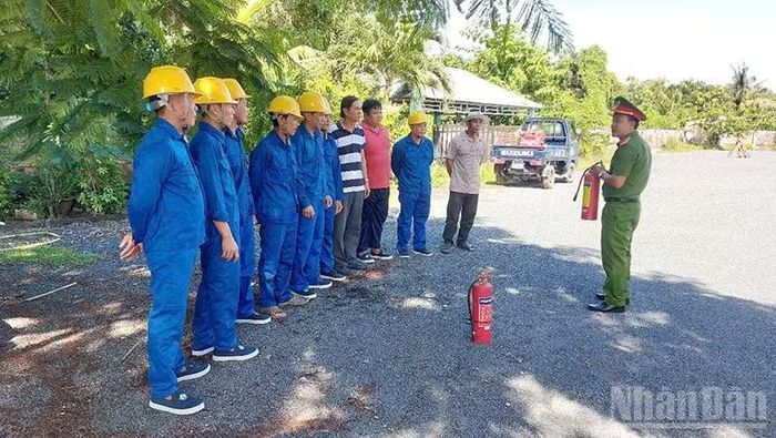 Đội được cán bộ Phòng Cảnh sát Phòng cháy, chữa cháy và cứu nạn, cứu hộ hướng dẫn sử dụng bình chữa cháy xách tay. (Ảnh: Công an Đồng Tháp)