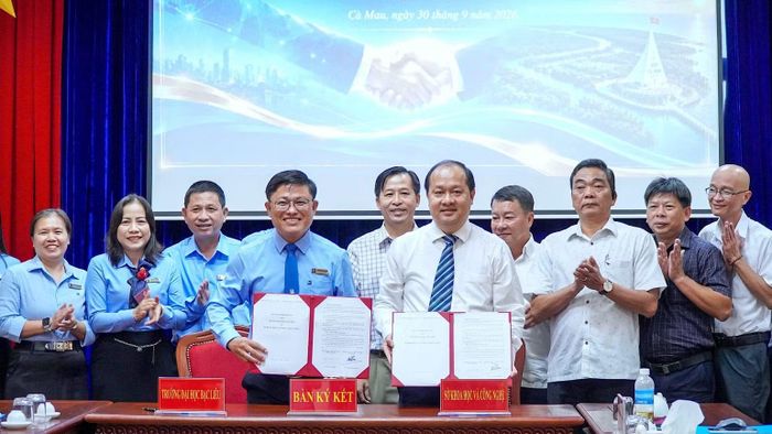 Lãnh đạo Sở Khoa học và Công nghệ tỉnh Cà Mau và Trường đại học Bạc Liêu trao biên bản ghi nhớ hợp tác trước sự chứng kiến của đại diện các đại biểu hai bên. (Ảnh: HOÀN THÀNH)