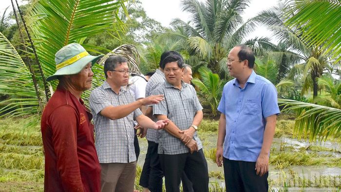 Bí thư Tỉnh ủy Cà Mau Nguyễn Hồ Hải (áo xanh) và Phó Chủ tịch Ủy ban nhân dân tỉnh Lê Văn Sử (thứ ba từ trái) thăm hỏi người dân ảnh hưởng bởi ngập úng. (Ảnh: HỮU TÙNG)