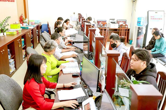Cán bộ, công chức Trung tâm Phục vụ hành chính công xã Bình Chánh, TPHCM giải quyết hồ sơ cho người dân, sáng 28-9. Ảnh: LÊ THOA