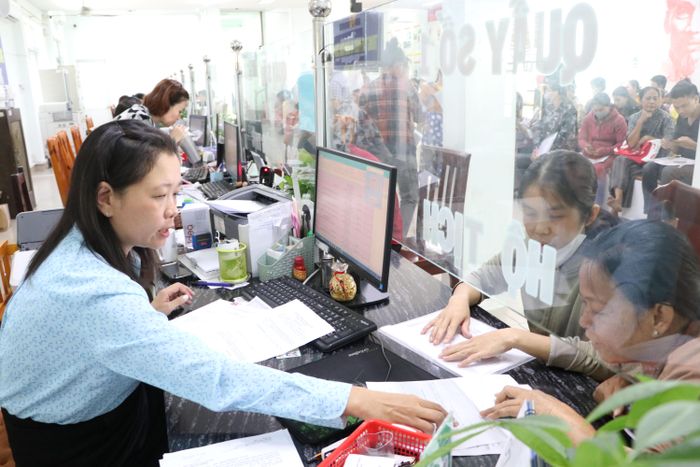Công chức Trung tâm Phục vụ hành chính công xã Đông Thạnh, TPHCM hướng dẫn người dân nộp hồ sơ trực tuyến. Ảnh: NGÔ BÌNH