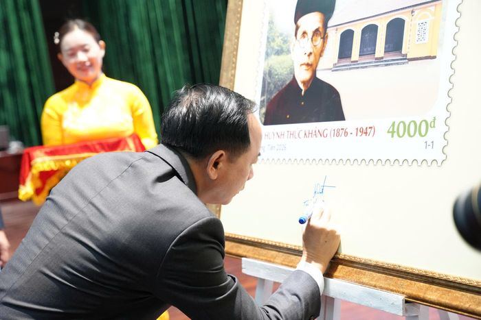  Trưởng Ban Tuyên giáo Trung ương Trịnh Văn Quyết ký lưu niệm trên bộ tem kỷ niệm 150 năm Ngày sinh cụ Huỳnh Thúc Kháng. Ảnh: NGUYÊN KHÔI 