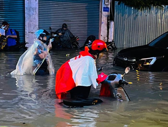  Đường Phan Huy Ích (đoạn qua phường Tân Sơn, TPHCM) ngập nặng, người dân dắt bộ xe qua dòng nước. Ảnh: KIẾN VĂN 