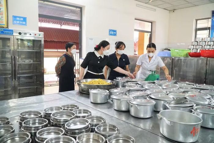 Cán bộ Ban giám hiệu Trường Tiểu học Vinh Phú 1 (phường Vinh Phú) kiểm tra nấu ăn bán trú cho học sinh tại trường. Ảnh: Hồ Lài