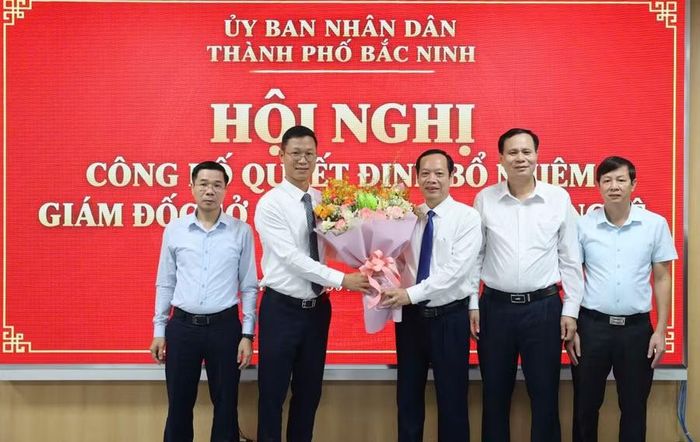 Phó Chủ tịch HĐND TP Bắc Ninh Nghiêm Xuân Hưởng tặng hoa chúc mừng ông Thân Trung Kiên nhận nhiệm vụ mới.