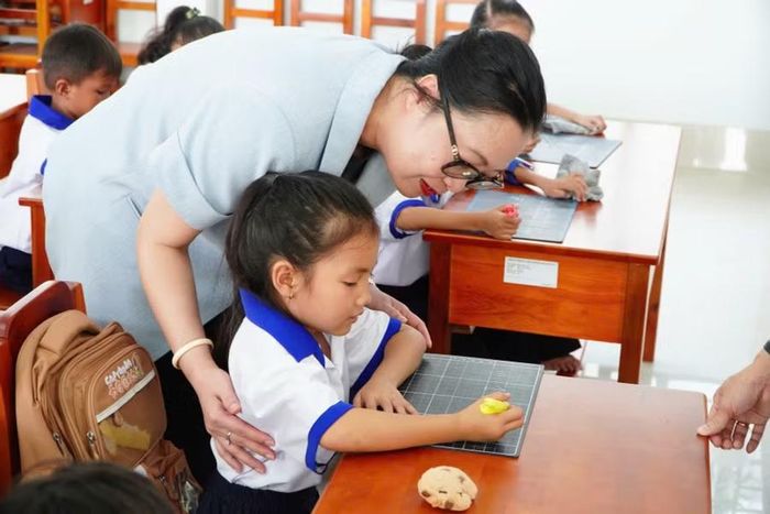 Thứ trưởng ân cần hướng dẫn, nâng niu từng nét chữ trên chiếc bảng nhỏ của học sinh tiểu học vùng biên. Các em học sinh cũng bày tỏ niềm phấn khởi khi nhận được sự quan tâm của Thứ trưởng Bộ GD&ĐT.