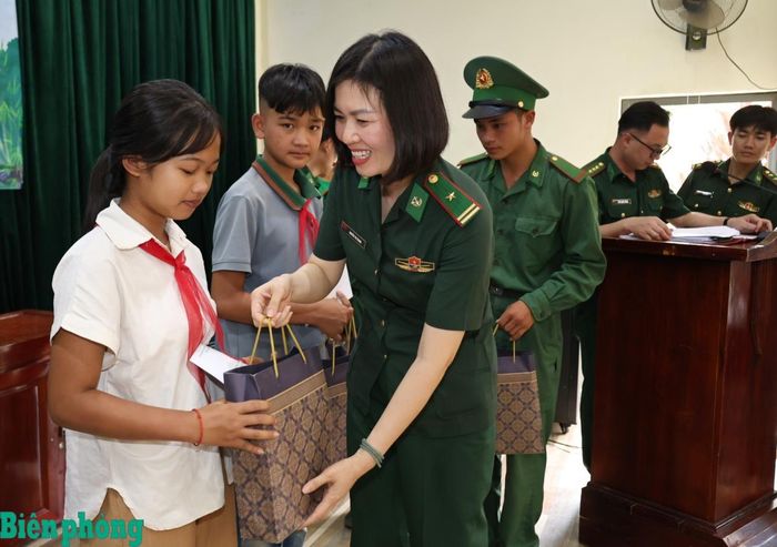 Thiếu tá Nguyễn Thị Trang, Chủ tịch Hội Phụ nữ cơ quan Cục Chính trị Bộ đội Biên phòng trao quà cho các em học sinh. Ảnh: Tuấn Kiệt