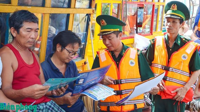 Cán bộ Đồn Biên phòng Phước Hải, Bộ đội Biên phòng thành phố Hồ Chí Minh tuyên truyền, giải thích các quy định pháp luật về khai thác thủy sản cho ngư dân địa phương. Ảnh: Quang Anh