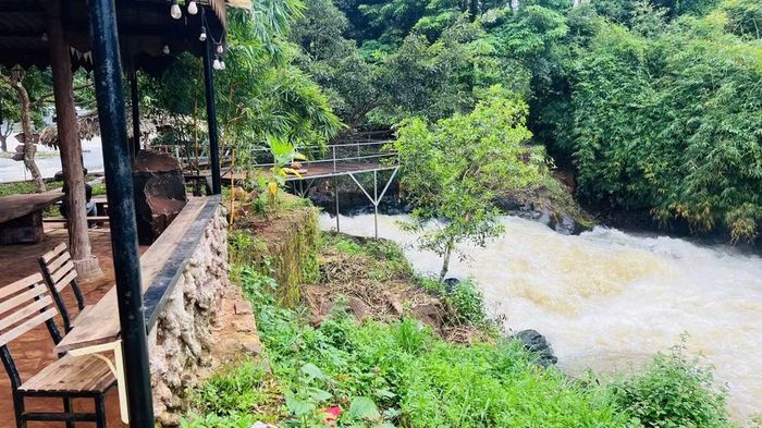 Bên cạnh chòi gỗ là thác nước cuồn cuộn đổ xuống