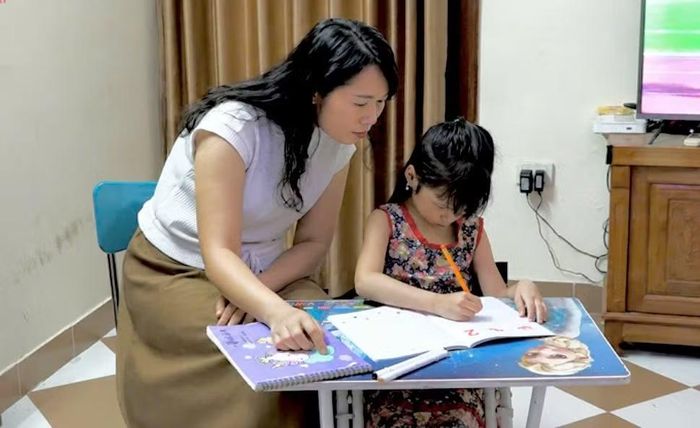 Sau giờ học ở trường, nhiều học sinh lớp 1 tiếp tục ngồi vào bàn học cùng cha mẹ. Ảnh: Duy Minh.
