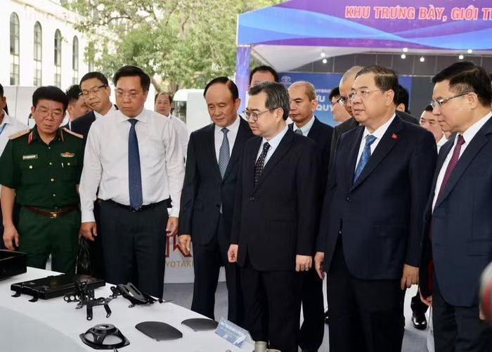Trưởng ban Chính sách, chiến lược Trung ương Nguyễn Thanh Nghị, Phó Thủ tướng Thường trực Chính phủ Phạm Gia Túc và các đại biểu tham quan gian trưng bày sản phẩm tại Hội thảo. Ảnh: CP
