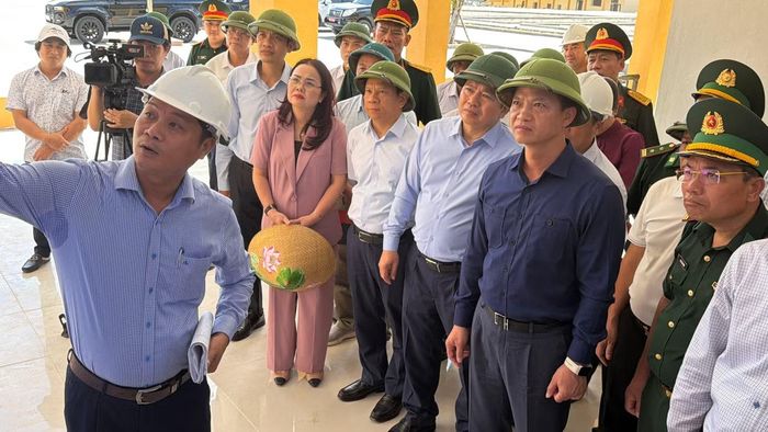 Bí thư Vương Quốc Tuấn (áo xanh đen, đội mũ cối) nghe chủ đầu tư báo cáo tiến độ.