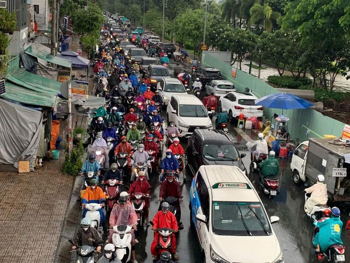 Dòng xe di chuyển chậm trên đường Ung Văn Khiêm, Nguyễn Gia Trí và Tầm Vu trong thời điểm mưa lớn sáng 30/9.