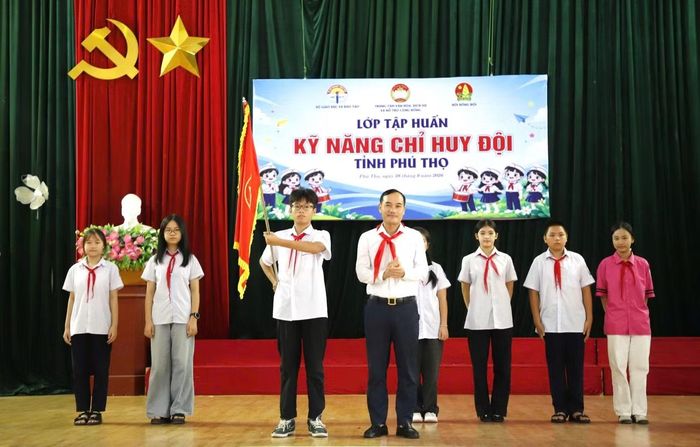 Anh Nguyễn Thành Luân - Phó Bí thư Tỉnh Đoàn, Giám đốc Trung tâm Văn hóa, Dịch vụ và Hỗ trợ cộng đồng tỉnh trao cờ cho Ban Chỉ huy Đội lâm thời trong thời gian tổ chức lớp học.
