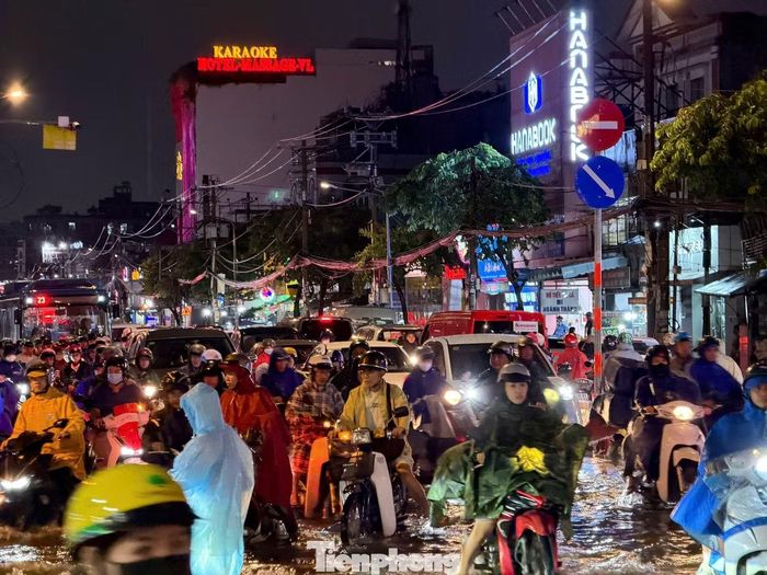 Người dân bì bõm dắt xe qua đoạn bị ngập trên đường Phan Văn Hớn.