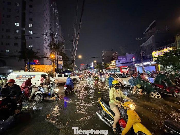 Các phương tiện nối đuôi nhau vượt qua khu vực bị ngập trên đường Phan Văn Hớn.
