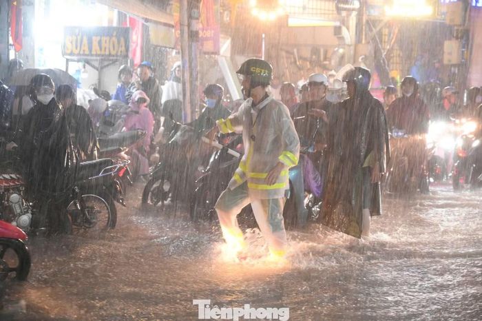 Tại giao lộ Linh Đông - Tô Ngọc Vân, lực lượng chức năng phường Hiệp Bình có mặt điều tiết giao thông, hỗ trợ người dân đưa xe qua những đoạn ngập sâu.
