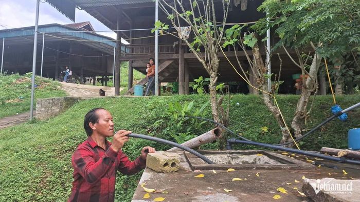 Ông Thò Bá Xô, Trưởng bản Minh Châu kiểm tra bể nước để có biện pháp sửa chữa tạm. Ảnh: Phạm Tiến
