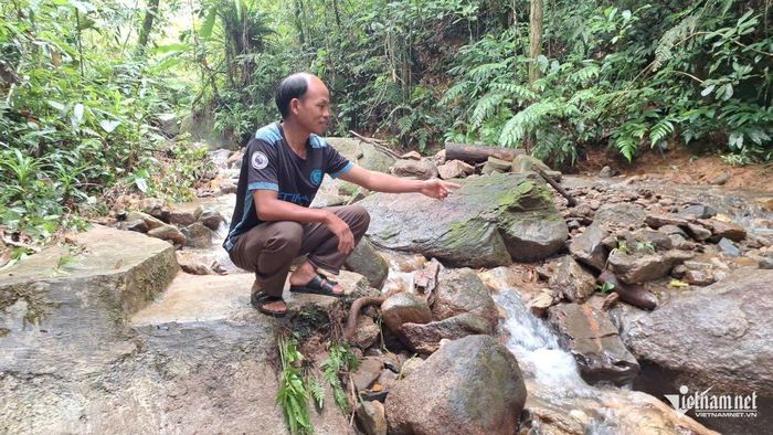 Ông Thò Bá Lý, Trưởng bản Pà Khốm, xã Tri Lễ (Nghệ An), chỉ vị trí bể thu nước bị lũ cuốn trôi. Ảnh: Phạm Tiến